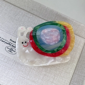 Macro shot of colorful acetate snail hair claw clip with rainbow shell on jewelry box