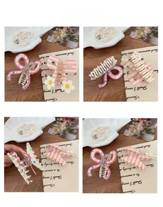 Close-up of sweet style acrylic hair claws with 3D floral and bow-knot striped patterns
