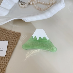 Dettaglio del fermaglio per capelli monte Fuji in acetato verde e bianco con brillantini