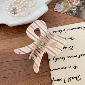 Detailed close-up of a pink heart pattern butterfly hair claw clip with golden spring