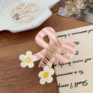 Detail of pink and beige striped bow hair claw clip with white floral accents