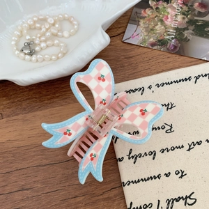 Pink checkered bow hair claw clip with cherry pattern on vintage wooden background