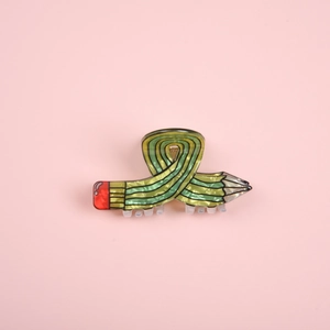 Close-up of creative pencil-shaped hair claw clip made of glossy acetate material