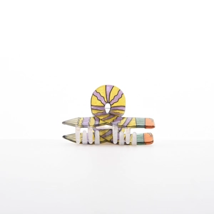 Macro shot of pencil-shaped hair claw clip with yellow and purple wavy textured pattern