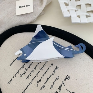 Dettaglio di un fermaglio per capelli a forma di razza con giunture in acetato blu e bianco