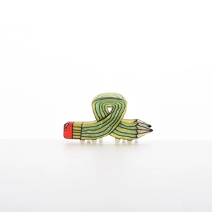 Detail view of a creative pencil shaped shark hair claw clip in yellow and green