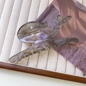 Vue détaillée d'une grande pince à cheveux baleine avec fini acétate iridescent