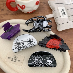 Gothic Halloween hair clips set featuring skull and spiderweb patterns on a tray