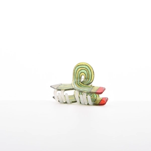 Close-up of a creative pencil-shaped hair claw clip with green and yellow stripes