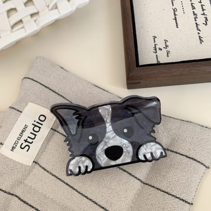 Detail of border collie hair claw clip with black and white marble pattern on textile