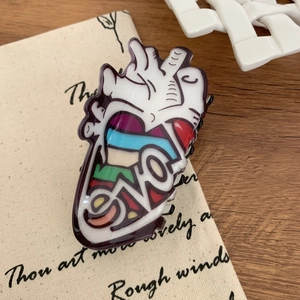 Detailed macro view of an anatomical heart hair claw clip with Love text on beige fabric