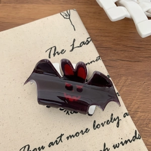 Close-up of a purple bat hair claw clip with red ear details for Halloween party styling
