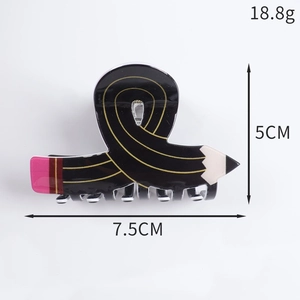 Dettaglio del fermaglio per capelli a forma di matita con strisce nere e gialle e gomma rosa