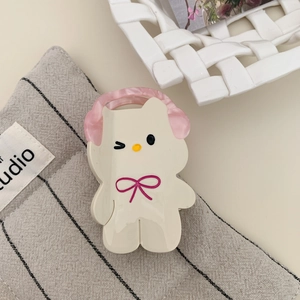 Detail of a cream acetate hair claw clip shaped like a cute cat with pink headphones