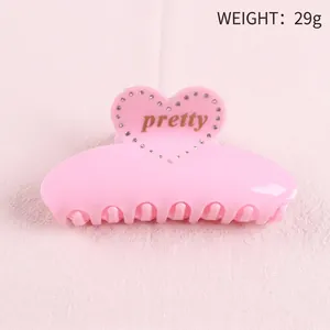 Detailed top view of pink resin heart hair claw clip with rhinestones and pretty text