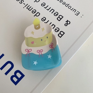 Dettaglio di una simpatica pinza per capelli a forma di torta con design colorato a strati