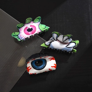 Lot de pinces à cheveux Halloween avec yeux de monstre et crocs sur fond sombre
