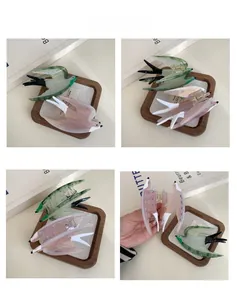 Detail view of swallow-shaped acetate hair claws in vintage green and purple textures