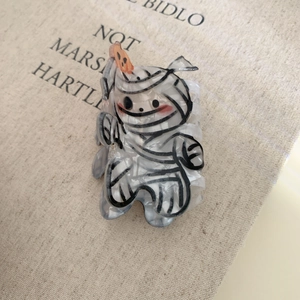 Macro shot of Halloween mummy claw clip with marble texture and orange detail