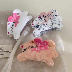 Three cute cat-shaped acetate hair claws with pink bows in marble and white colors