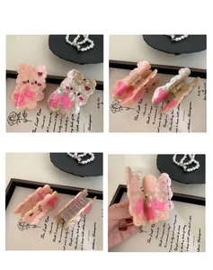 Dettaglio delle mollette in acetato a forma di orso con fiocchi rosa eleganti