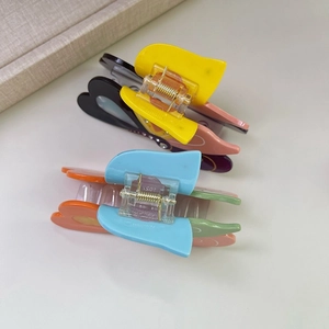 Dettaglio di fermagli per capelli a farfalla colorati con texture in acetato e strass