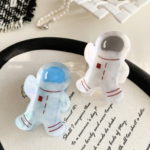 Detailed shot of two cute astronaut hair claws in white and blue acetate with marble texture