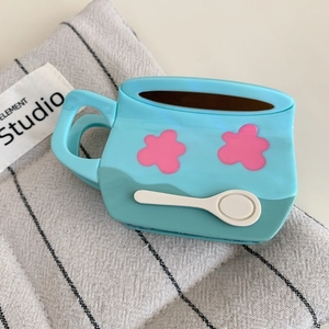 Gros plan sur l'étui à écouteurs en silicone bleu clair avec design de tasse et fleurs