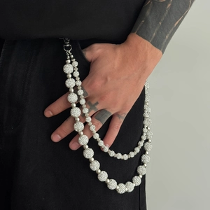 Detail of hip hop iced-out pants chain with rhinestone beads on black denim jeans