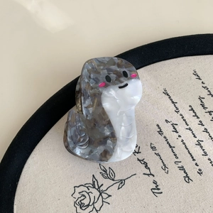 Detailed view of the cute seal hair claw clip in tortoiseshell acetate on a vintage backdrop