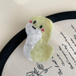 Detailed macro view of the cute green snake hair claw clip with marble texture