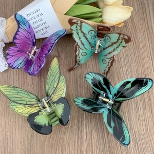 Lot de quatre pinces à cheveux papillon réalistes de couleurs variées sur bois