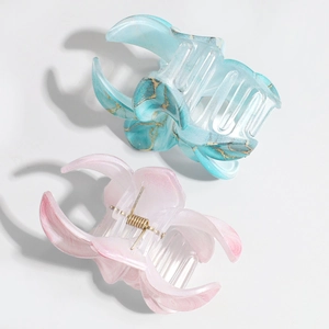 Detailed view of marble texture hair claws with elegant blue and pink resin patterns