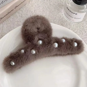 Pince à cheveux en peluche marron avec perles sur une assiette décorative en céramique