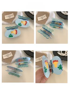 Macro details of light blue acetate fish hair claw clip with yellow goldfish patterns