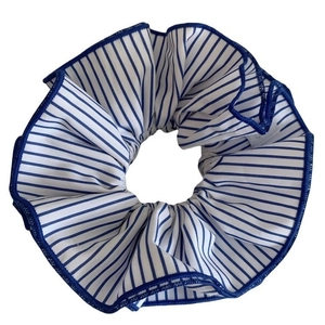 Chouchou en tissu à rayures bleues et blanches avec bordure foncée sur fond blanc