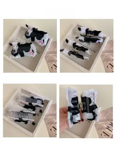 Détails sous quatre angles d'une pince à cheveux motif vache brillante avec touches roses