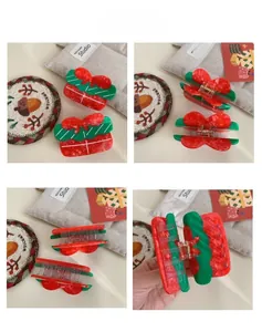 Detail of Christmas gift box hair claw with festive red and green acetate bow design