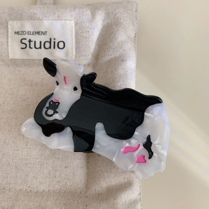 Détail de la pince à cheveux motif vache avec texture en acétate marbré noir et blanc