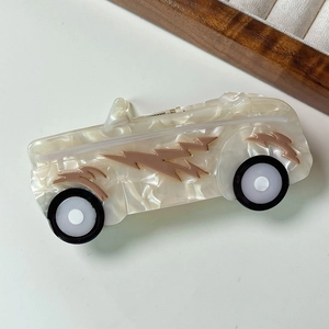 Détail de la pince à cheveux en forme de voiture rétro en acétate de cellulose blanc