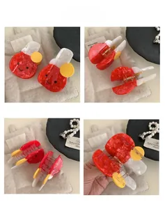 Detail view of red marble acetate hair claw clip with yellow accents and a smile face design