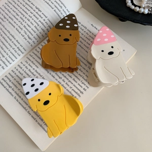 Trois pinces à cheveux chien labrador avec chapeaux à pois sur une page de livre ancien