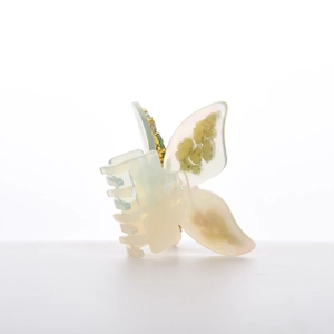 Detail of cream acetate butterfly hair claw clip with floral patterns and pearl finish