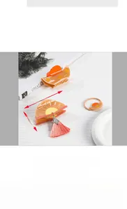 Detail showing amber fan-shaped hair claw with pink tassel and 80mm size dimensions