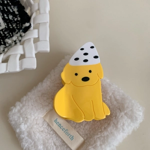 Détail d'une pince à cheveux Labrador jaune avec chapeau à pois sur fond en peluche
