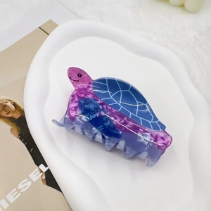 Detailed view of sea turtle claw clip with blue marble pattern on white tray