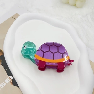 Detail of creative sea turtle hair claw clip with colorful tortoise shell pattern texture
