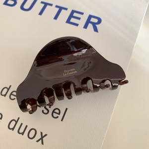 Nahaufnahme der dunkelbraun glänzenden Acetat-Haarklammer mit goldenem Barrette La France Text