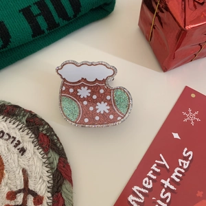 Detail der glitzernden rosa und mintgrünen Haarklammer im Weihnachtsstrumpf-Design mit Flocken
