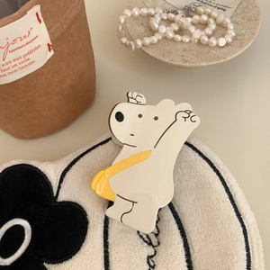 Vue détaillée d'une pince à cheveux ours crème avec un décor de sac à main jaune